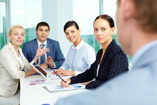Group of business people looking at their employer while consulting in office