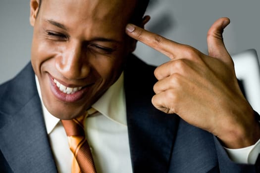 Image of confused man touching his temple with forefinger and smiling