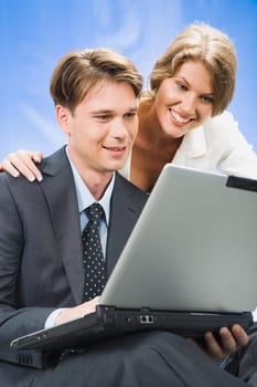 Young woman looks in the laptop with her colleague