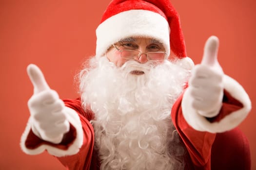 Photo of happy Santa Claus showing both thumbs up and looking at camera