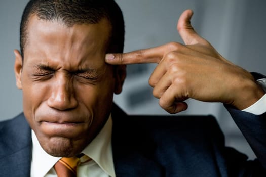 Image of confused man touching his temple with forefinger in trouble