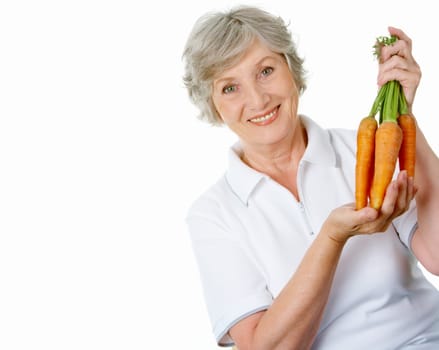 Portrait of elderly woman with ripe carrots smiling at camera over white background