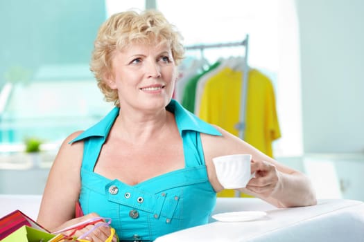 Portrait of middle aged woman with cup of coffee looking somewhere