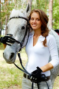 Image of happy female looking at camera with horse near by