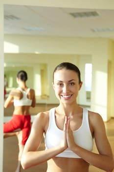 Portrait of smiling girl doing physical exercises and looking at camera