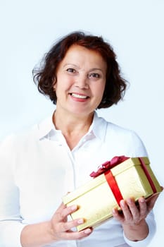 Portrait of middle-aged female with golden giftbox looking at camera