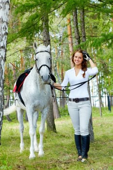 Image of happy female looking at camera with horse near by