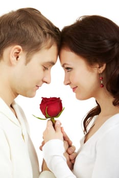 Portrait of two young people looking at each other and holding a rose