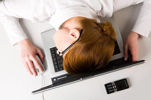 Image of very tired businesswoman or student putting her face on keyboard of laptop