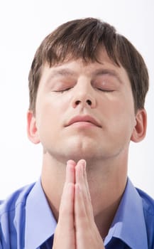 Face of young man with closed eyes and his hands keeping in touch beneath his chin