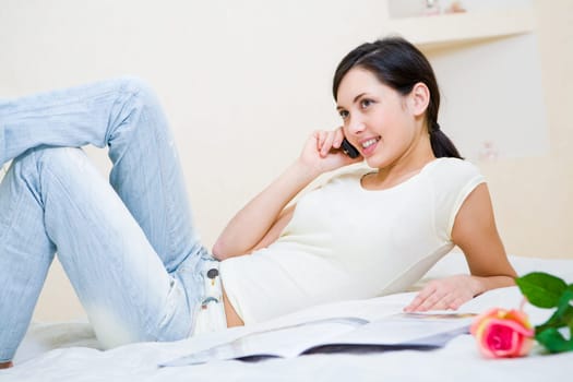 Image of pretty teenager speaking by the phone in a good mood