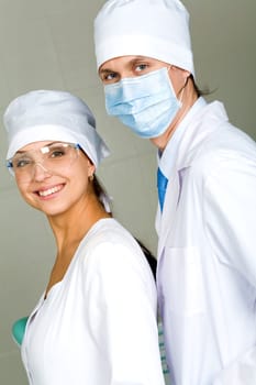 Image of confident doctor with his pretty assistant both looking at camera