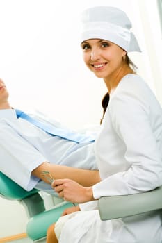 Portrait of young professional looking at camera on background of patient