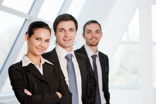 Portrait of confident co-workers standing in line with pretty employer in front