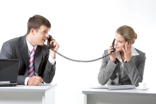 Portrait of business partners speaking on the telephone and looking at each other