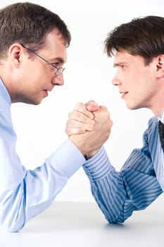 Conceptual photo of business competition: two businessmen wrestling with aggressive expression on their faces