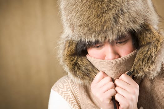 Portrait of cold man in fur hat and knitted scarf warming up