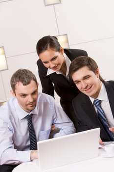 Portrait of executive employees looking at laptop monitor with smiles and thinking about new project