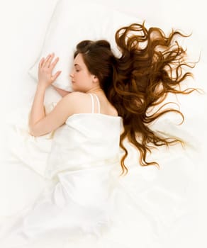 View of pretty young female lying in bed and having rest