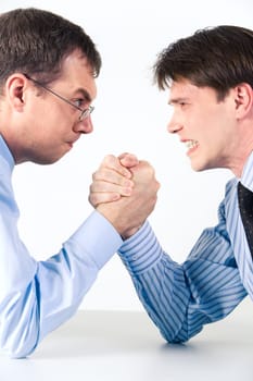 Conceptual photo of business competition: two businessmen wrestling with aggressive expression on their faces