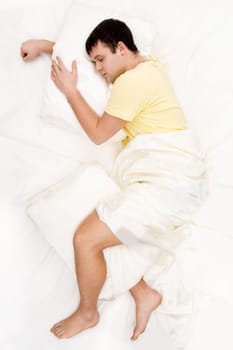 Above view of peaceful man having pleasant sleep on his comfortable bed