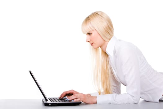 Image of pretty female lying before laptop and typing