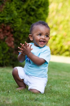 Portrait of a little african american baby boy playing outdoor in the grass