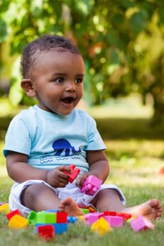 Portrait of a little african american baby boy playing outdoor in the grass