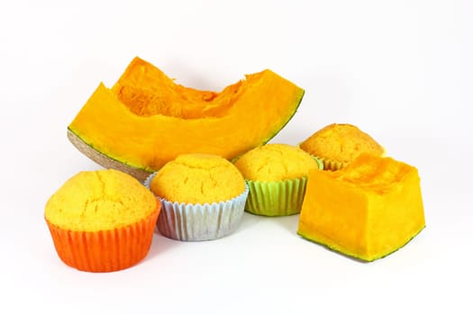 Fresh baked pumpkin muffins with piece of pumpkin isolated on white