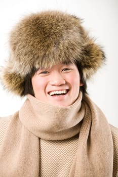 Portrait of happy man in warm fur hat and white sweater laughing