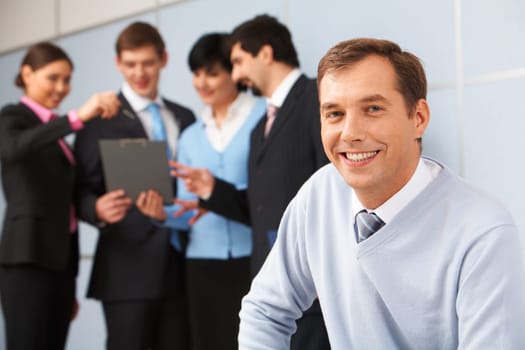Photo of happy man looking at camera in working environment