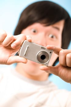 Image of photo camera in surprised male hands after making a shot