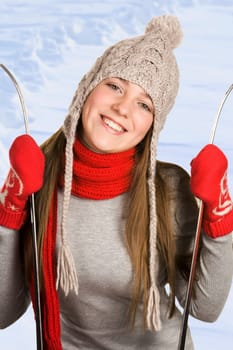 Portrait of smiling female holding skis with snowdrift at background