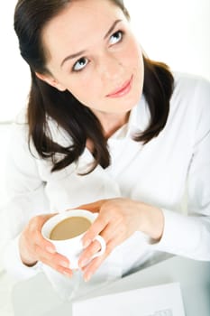 Vertical image of smart business lady looking up and holding cup of coffee in hands