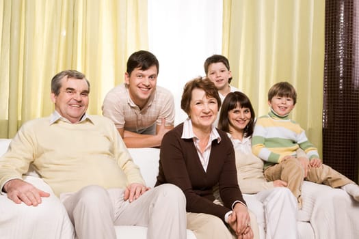 Portrait of senior and young couples with their children looking at camera at home