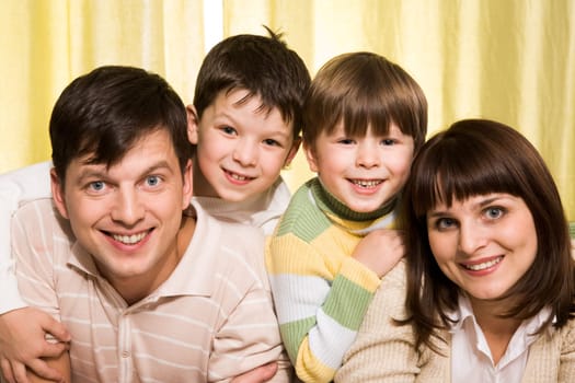 Portrait of cheerful parents with their two children on a white background