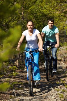 A young people riding bicycles in wood