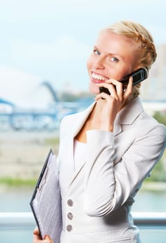 Portrait of elegant businesswoman looking at camera while speaking on the phone