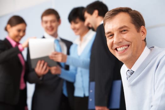 Photo of happy man looking at camera in working environment
