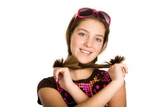 Portrait of cute girl crossing her pony tails by neck looking at camera with smile