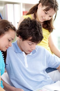 Three teenagers reading something together