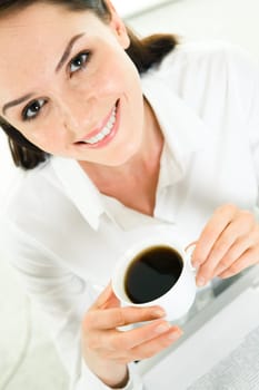 Close-up of business ladys face having coffee break and looking at camera with smile