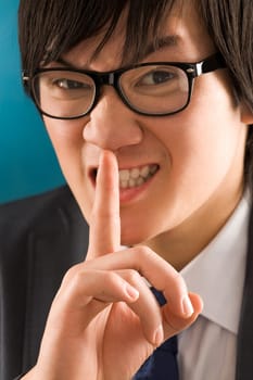 Portrait of young businessman with the finger near mouth