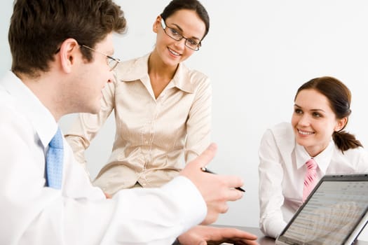 Business-team of three smiling people discussing new working ideas
