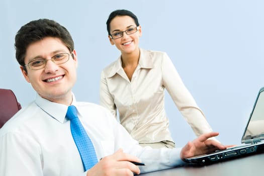 Photo of smiling confident boss looking at camera with woman sitting near by