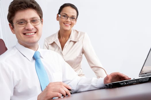 Photo of smiling confident boss looking at camera with woman sitting near by