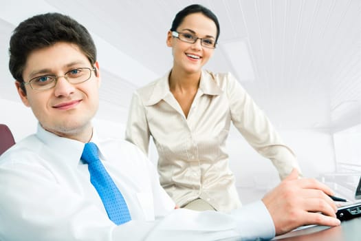 Portrait of confident boss sitting at the table on the background of happy woman