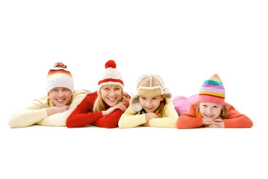 A family of four in warm clothes lying and smiling isolated on white