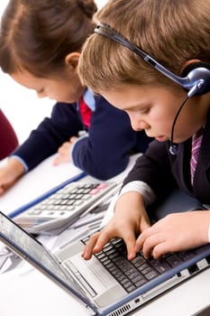 Photo of serious businesschild with headset typing at briefing
