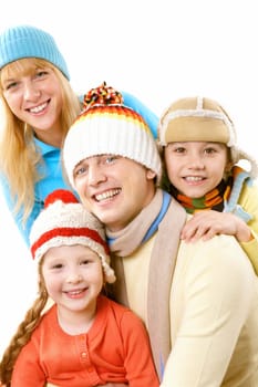 A happy family of four in warm clothes embracing